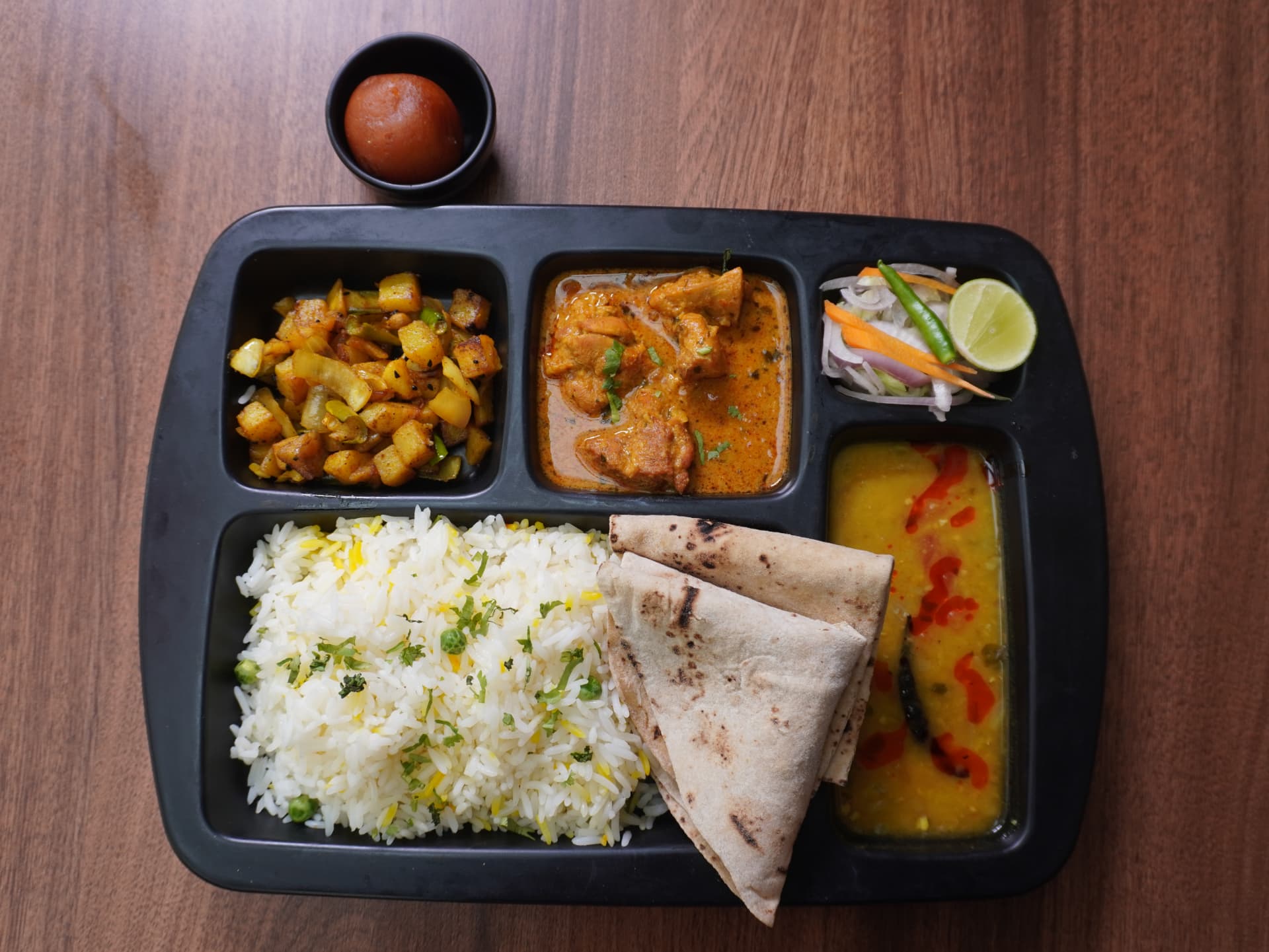 Lunch thali with rice, chicken curry, dal, roti and gulab jamun
